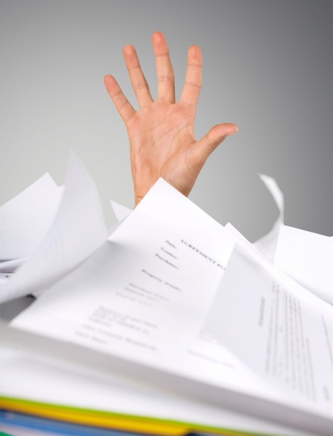 Hand of business person on background of stacked papers