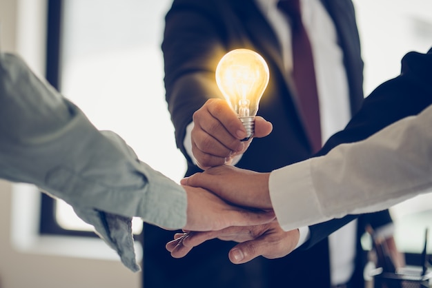 Hand of businessman holding light bulb as symbol of success idea