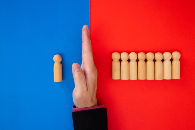 Hand of businessman stops falling figures of people employees