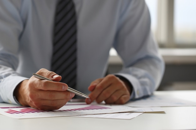 Hand of businessman in suit filling and signing with