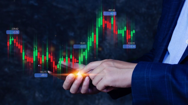 Hand of businessman or trader is showing growing virtual hologram stock on smartphone planning and strategy Stock market Business growth progress or success concept invest in trading