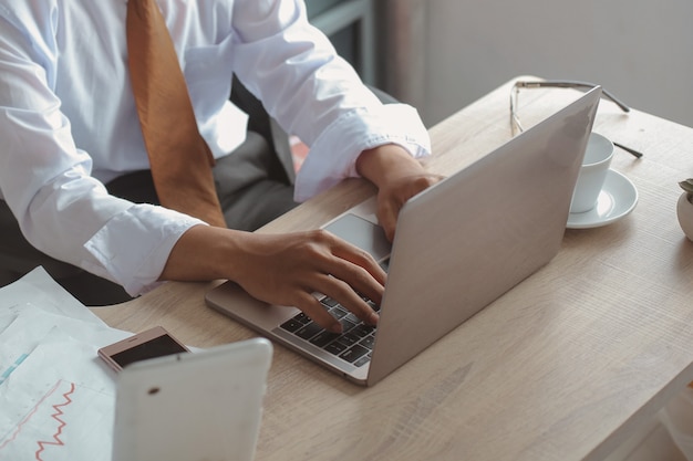 Hand of businessman typing on laptop keyboard on office desk