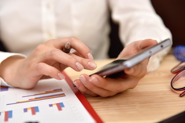 Hand of businesswoman touching phone