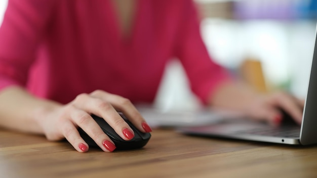 Hand of businesswoman working at computer using mouse closeup