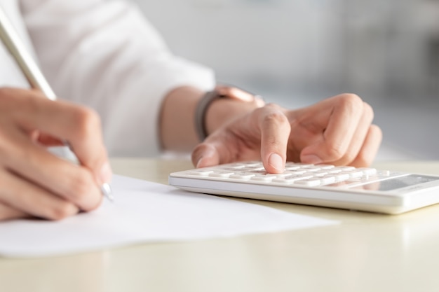 Hand of businesswoman writing on paper in the office