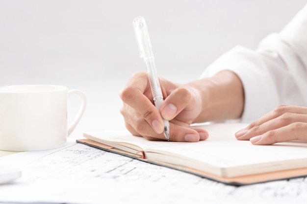 Hand of businesswoman writing on paper in the office