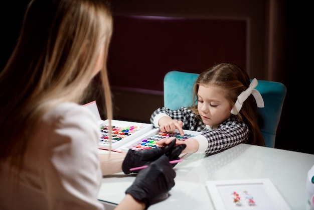 Hand care in the salon for a little girl in the evening