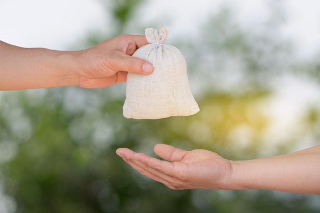 Hand catch giving and receipt money bag blur bokeh background