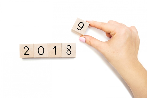 Hand changing cube, symbolizing the change from 2018 to 2019. Isolated on white