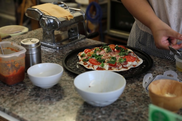 Hand of chef making pizza at homemade kitchen