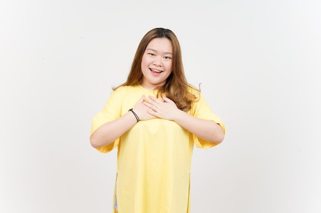 Hand on chest grateful gesture of Beautiful Asian Woman wearing yellow TShirt Isolated On White