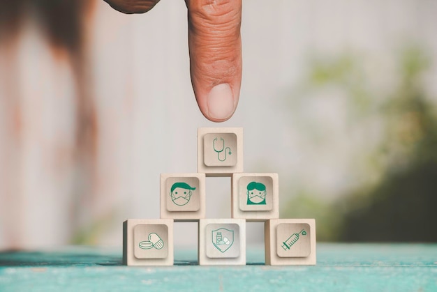 Hand chooses icons healthcare medical symbol on wooden block vaccine