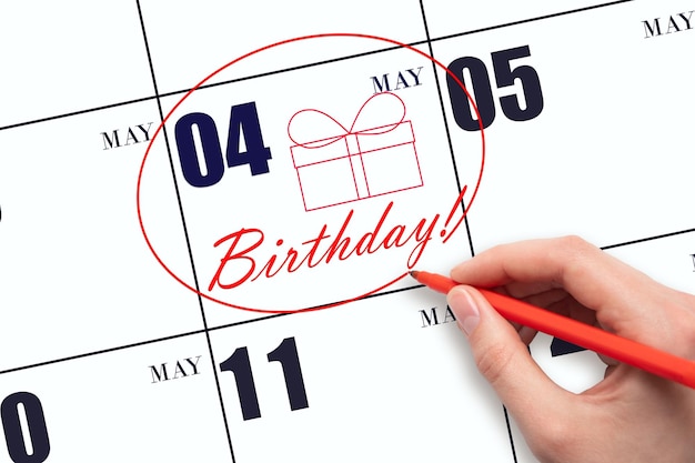 The hand circles the date on the calendar 4 May draws a gift box and writes the text Birthday Holiday