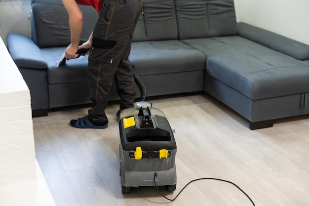 Hand cleaning a sofa with a steam cleaner, Home cleaning concept.