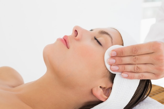 Hand cleaning woman&#039;s face with cotton swab