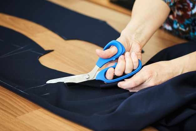 Photo hand cut fabric with scissors on the table