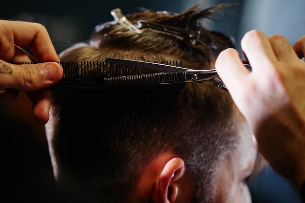 Hand cut with scissors the man in Barbershop closeup