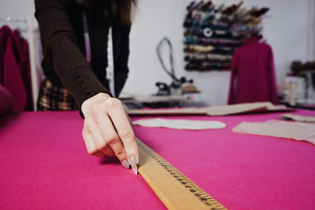 Photo hand cutting pattern and fabric pieces fashion design female tailor seamstress working with sewing