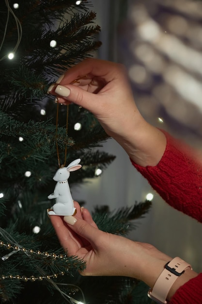 Hand decorating christmas tree decoration hare symbol of the year 2023