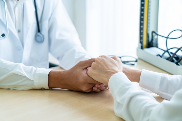 Hand of doctor reassuring her female patient