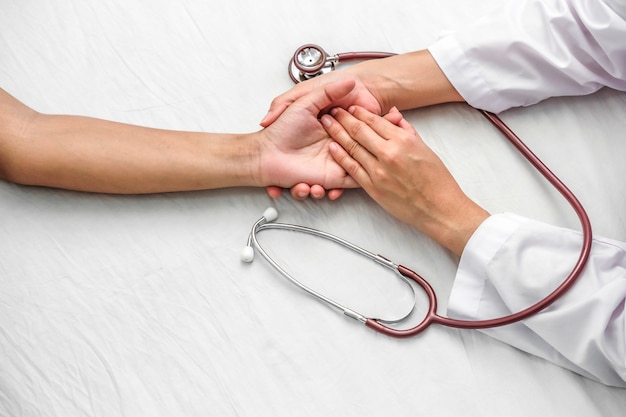 Photo hand of doctor reassuring her female patient