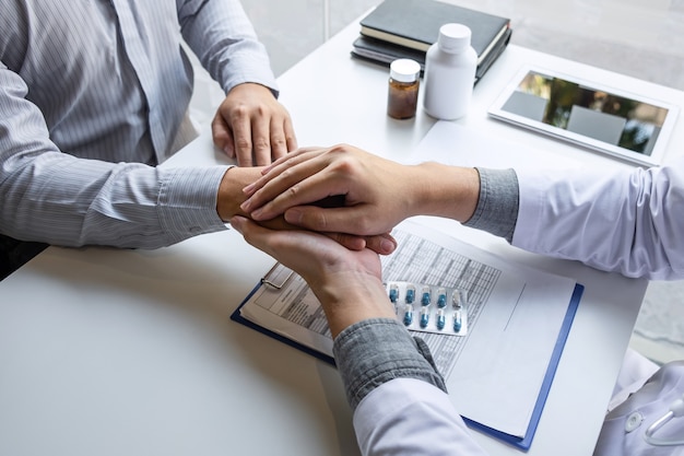 Hand of doctor touching patient reassuring for encouragement and empathy to support while medical examination on the hospital.