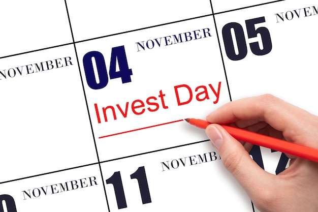 Hand drawing red line and writing the text Invest Day on calendar date November 4 Business and financial concept