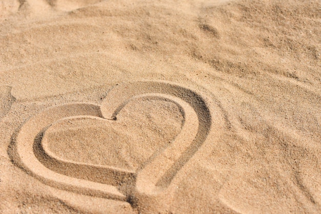 Photo hand drawn heart on sea sand on the beach