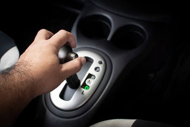 Hand of driver put a gear stick into D position, (Drive) Symbol in auto transmission car.