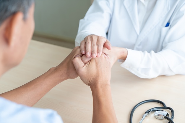 Hand of female doctor holding on her senior patient