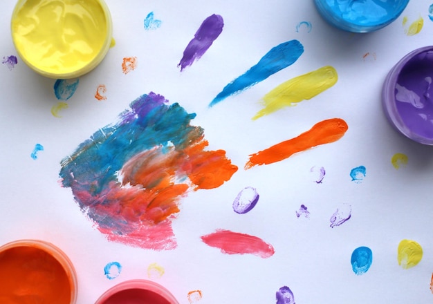 Hand and finger print with multicolored finger paints on a light background