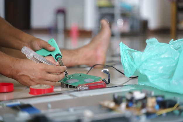 Hand fixing broken electronic board or pcb