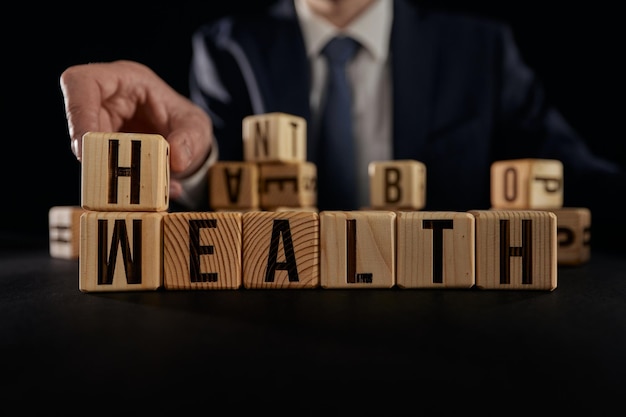 Hand flip wooden cube with word wealth to health