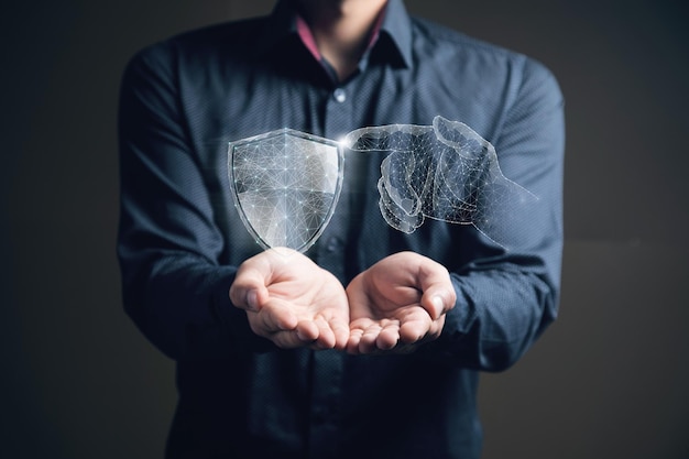 A hand from the net presses the shield Cyber protection Man holding in his hand