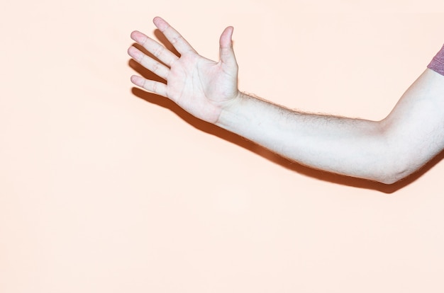 Hand gesture on orange background. Open hand greeting gesture