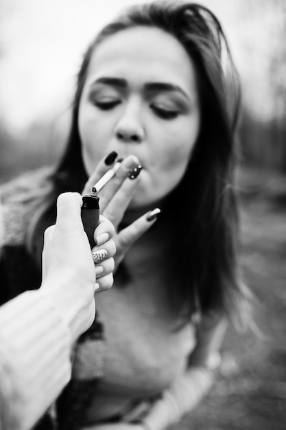 Hand of girl with cigarette lighter Stop smoking social problem Friends smoke