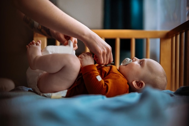 Hand gives baby boy with blue eye a pacifier