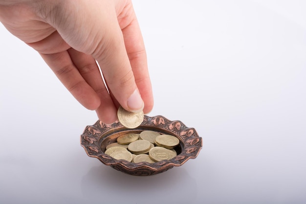 Hand giving money to a bowl