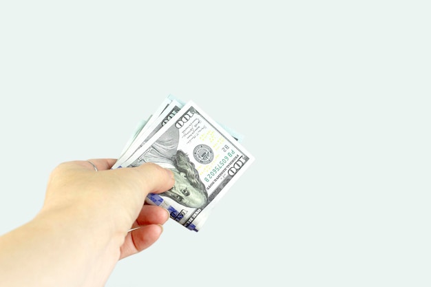 Hand giving money US dollars on grey background Finance earnings crediting