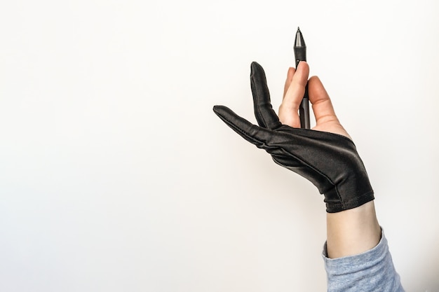 A hand in a glove holding a stylus.