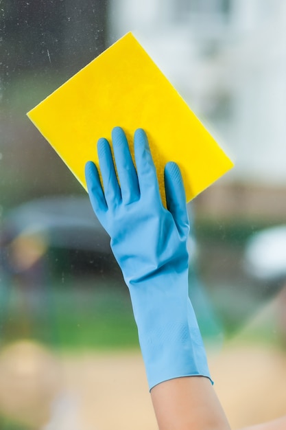 Hand in glove washes a window