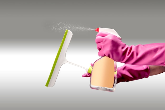 Hand in gloves using cleaning spray and cleaning tools 