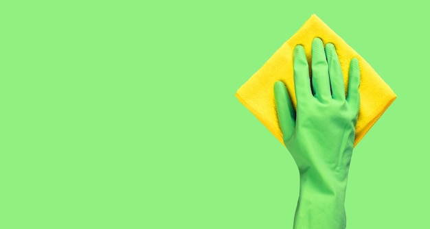 Hand in green glove holding micro fiber cloth for wiping Banner background with copy space for text