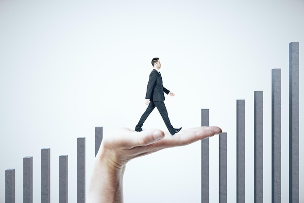 Hand helps a businessman climb on a business graph on white background