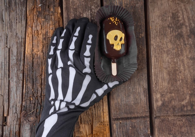 Hand hold chocolate cake with gold skull