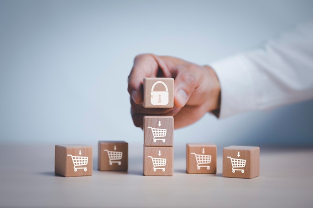 Hand hold cubes woods key block step on table with icon shopping cart on the White background, product price reduction, online shopping concept, project management, company strategy development.