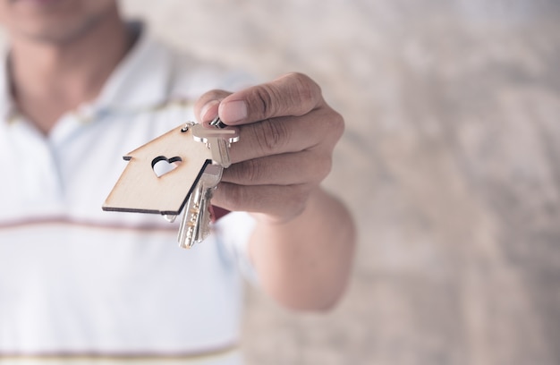 hand hold key and house model in saving plan for residence of people in society.