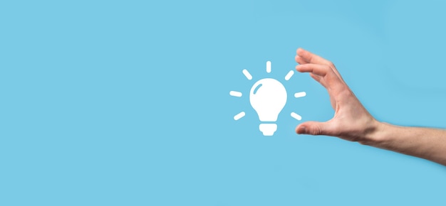 Hand hold light bulb. Holds a glowing idea icon in his hand. With a place for text.The concept of the business idea.Innovation, brainstorming, inspiration and solution concepts.