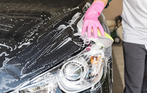 Hand hold sponge over the car for washing