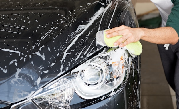 Hand hold sponge over the car for washing